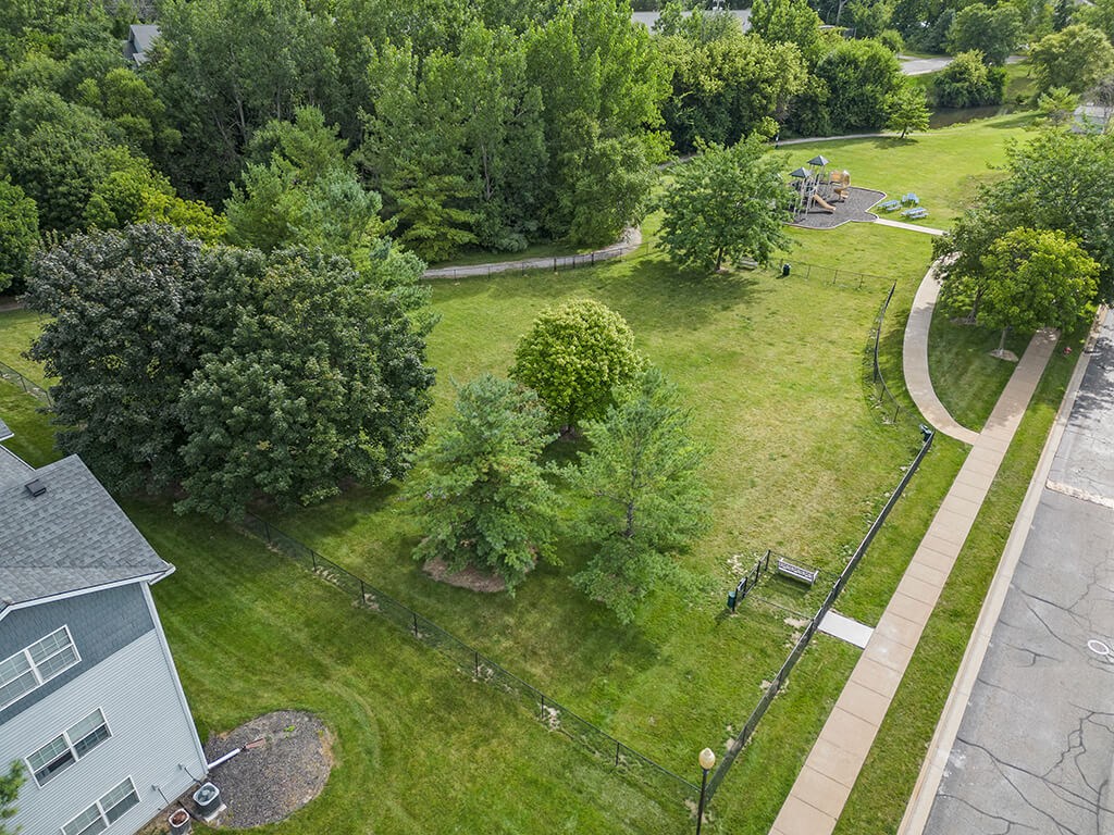 an aerial view of a dog park with trees and a sidewalk