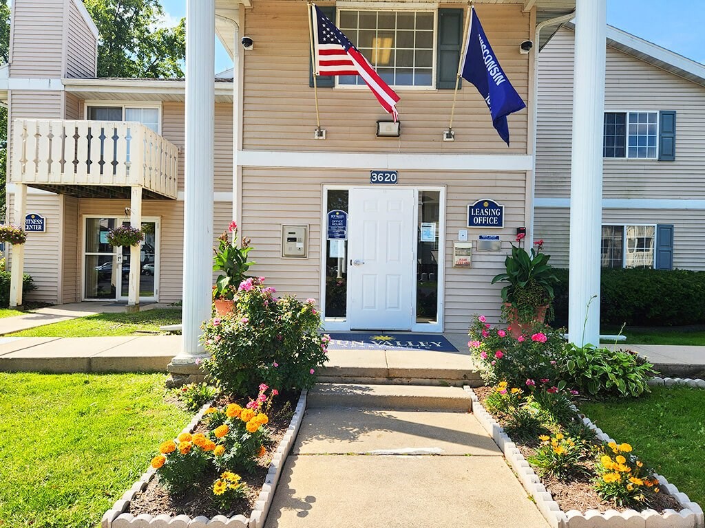 The front of a building with a white door and a sign that says