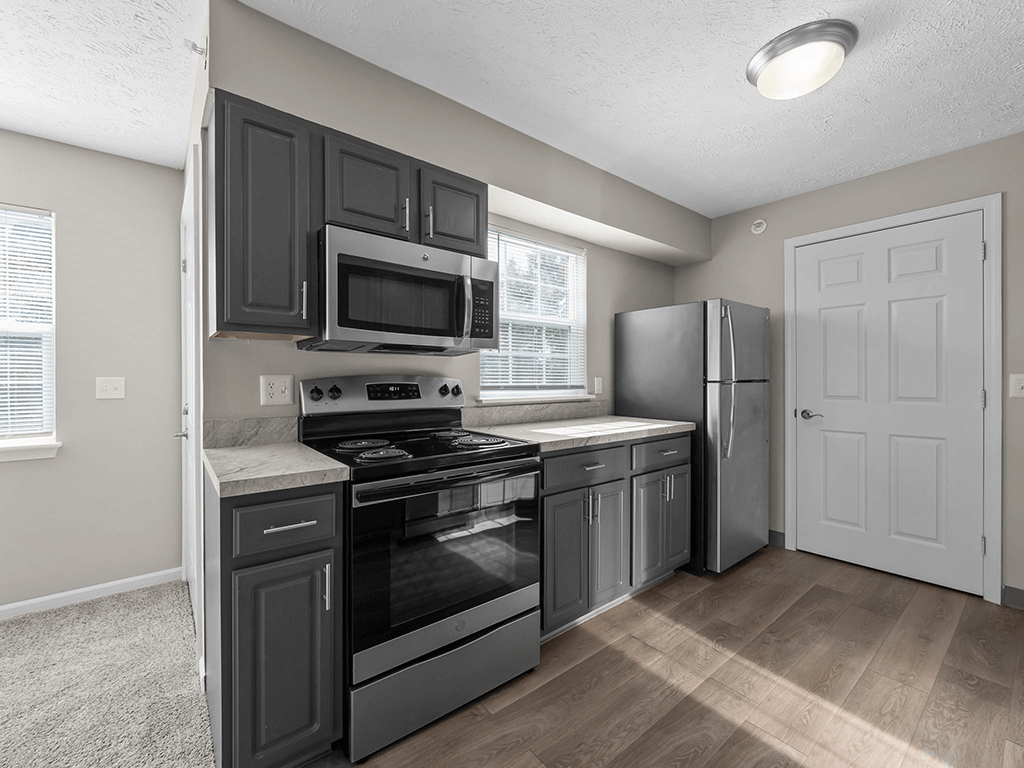 a kitchen with black cabinets and stainless steel appliances
