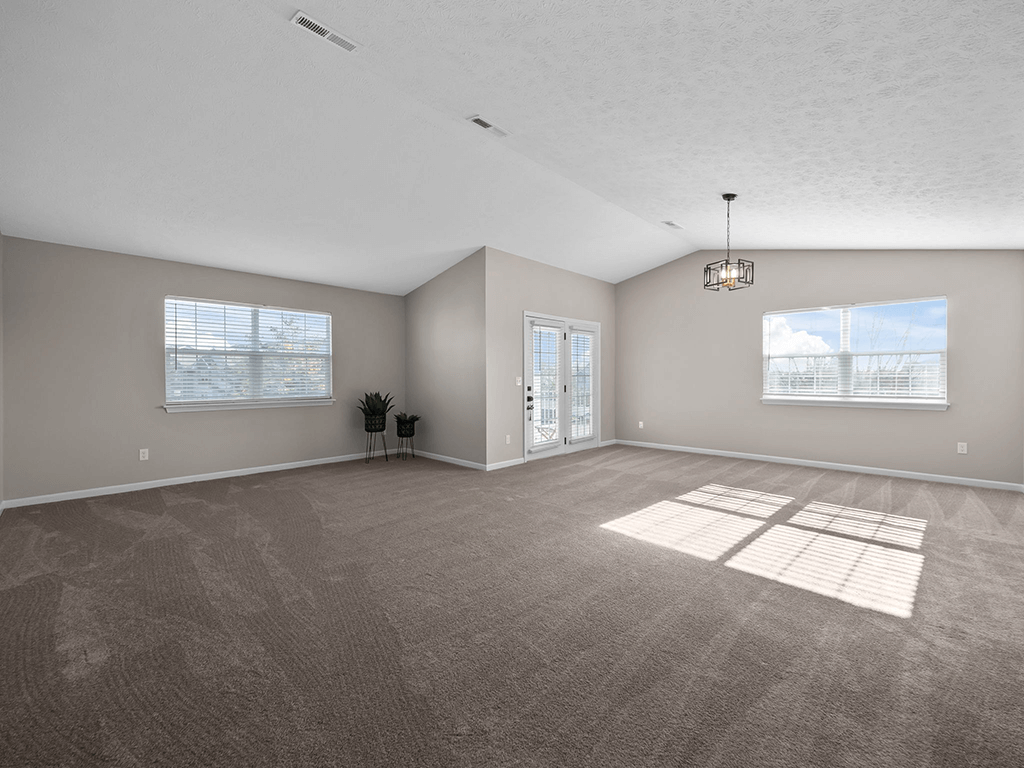 an empty living room with a door to a patio