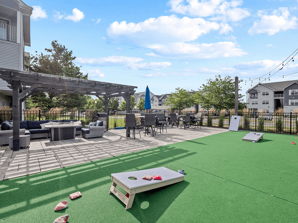the clubhouse patio with tables and chairs and a putting green