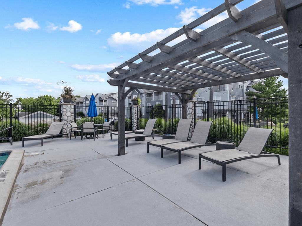 an outdoor patio with lounge chairs and a pergola