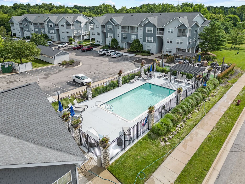 an aerial view of a swimming pool in front of an apartment building