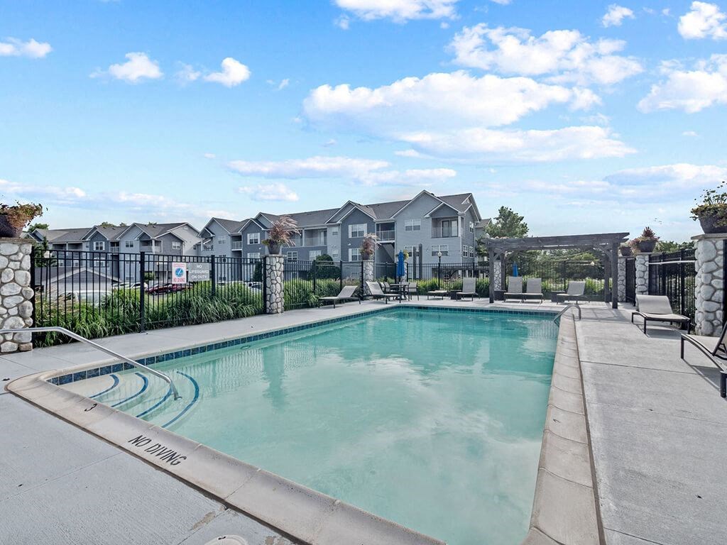 a swimming pool with apartment buildings in the background