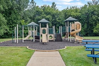 a playground with a slide and other playground equipment at an apartment community