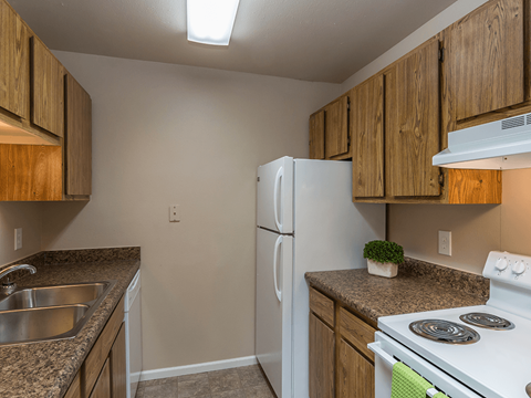 A kitchen with a white refrigerator and stove top oven.