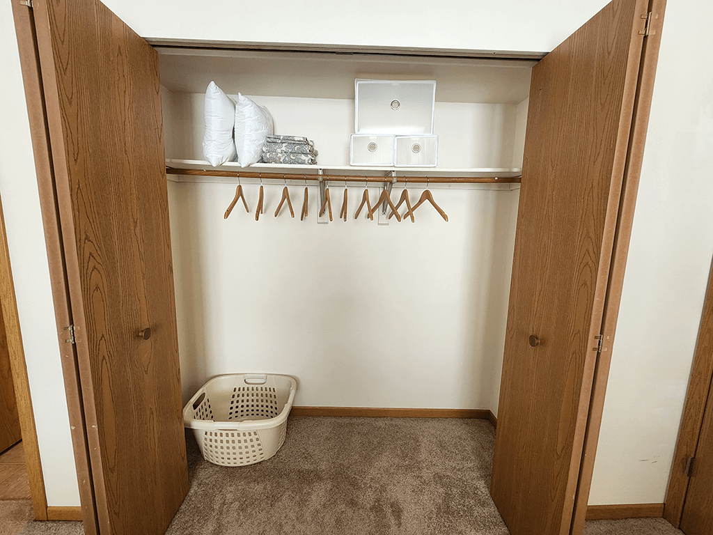 A laundry room with a basket and clothes hangers.