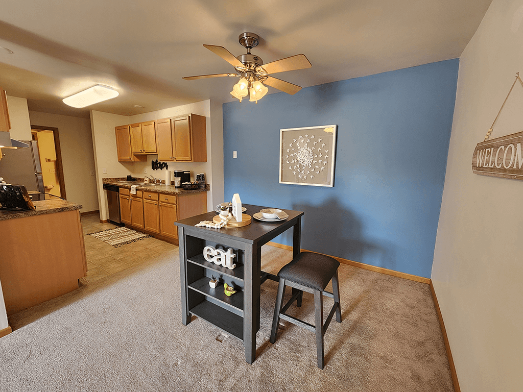 A kitchen with a dining table and chairs in the middle of the room.