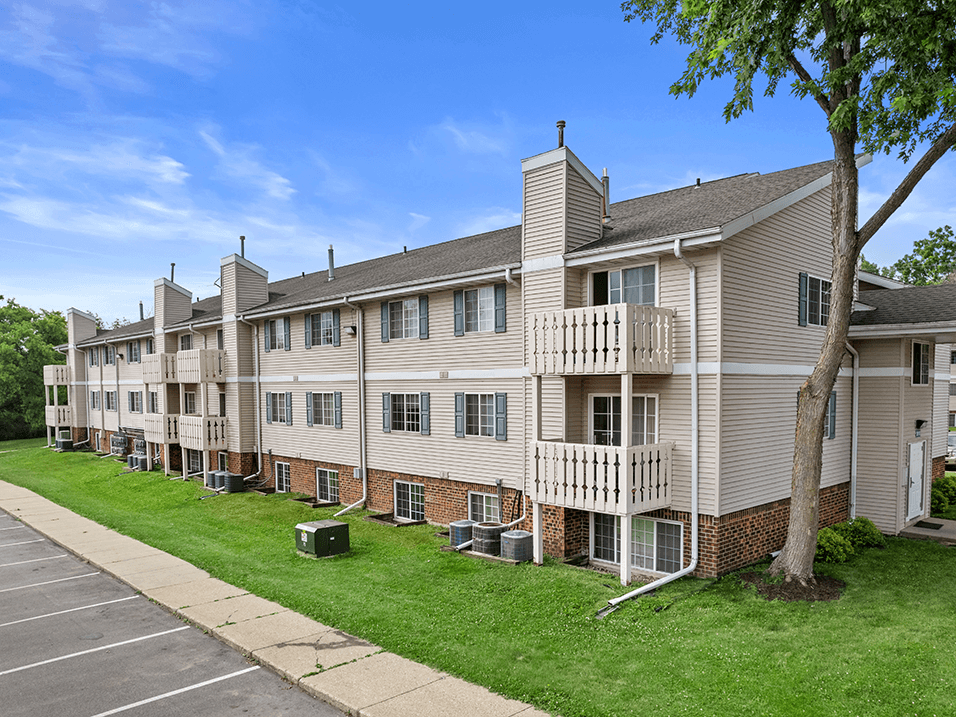 an image of an apartment building with green grass and trees at sun valley apartments
