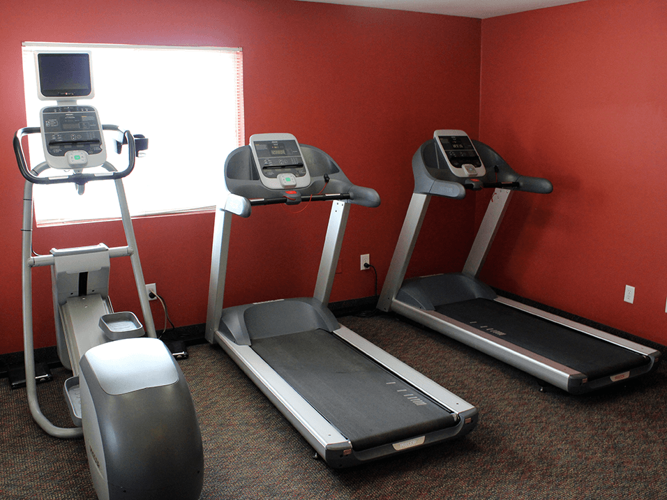 a gym with two treadmills and other exercise equipment at sun valley apartments
