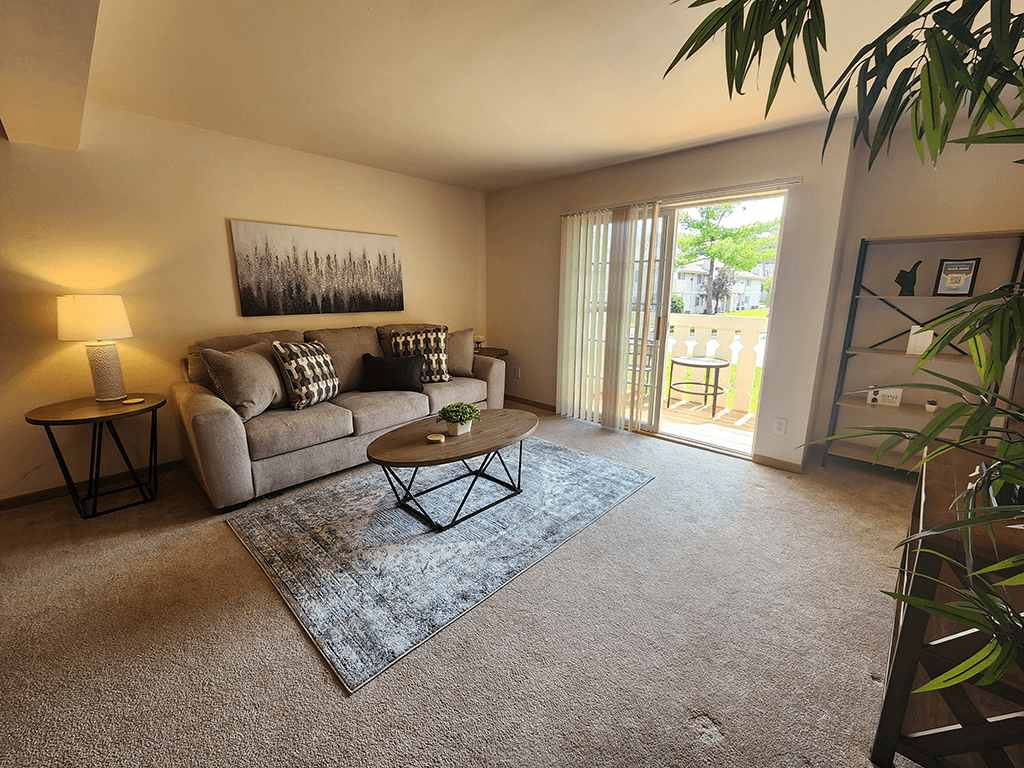 A living room with a couch, a coffee table, and a painting on the wall.