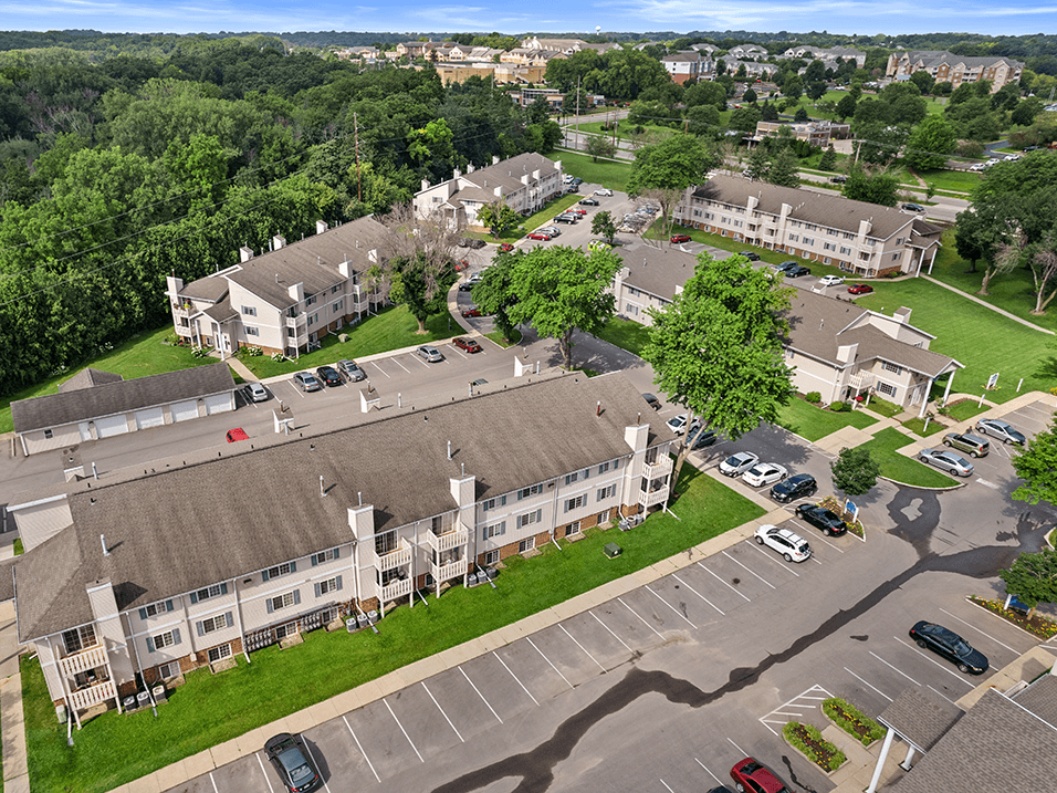 an aerial view of an apartment complex with cars parked in a parking lot