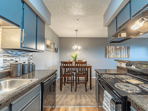a kitchen with stainless steel appliances and a dining room table