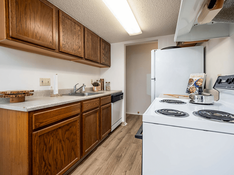 A kitchen with wooden cabinets and a white stove top oven.