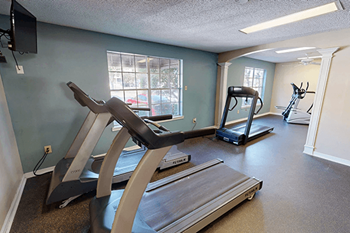 A gym with treadmills and elliptical machines.