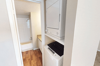 A white dishwasher is in a kitchen next to a white oven.