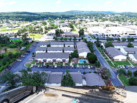 A parking lot is in the foreground of a residential area.