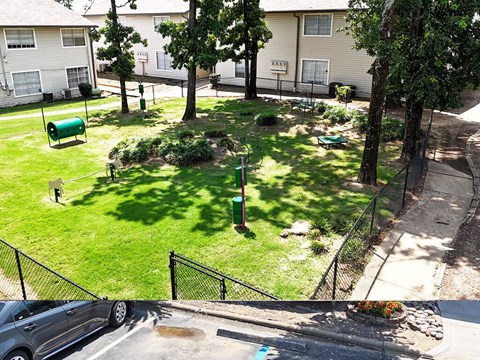 A green mailbox sits on a lawn in front of a house.