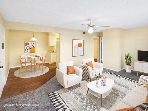 A living room with a white couch, a coffee table, and a ceiling fan.