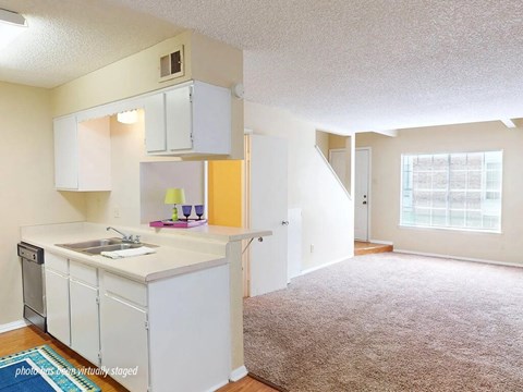 A kitchen with white cabinets and a sink.