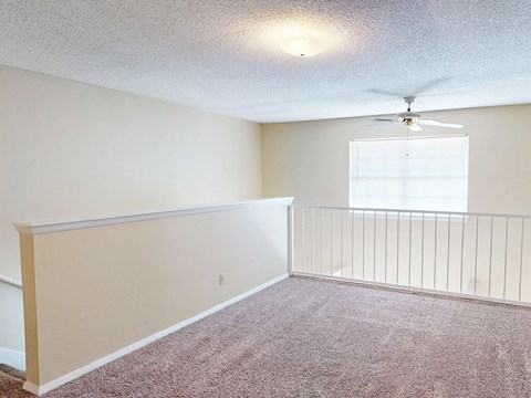 A room with a ceiling fan and a window with blinds.