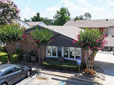 A car is parked in front of a building with a sign that says