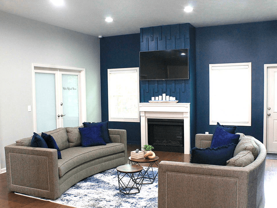 a living room with blue walls and a fireplace with a tv above it