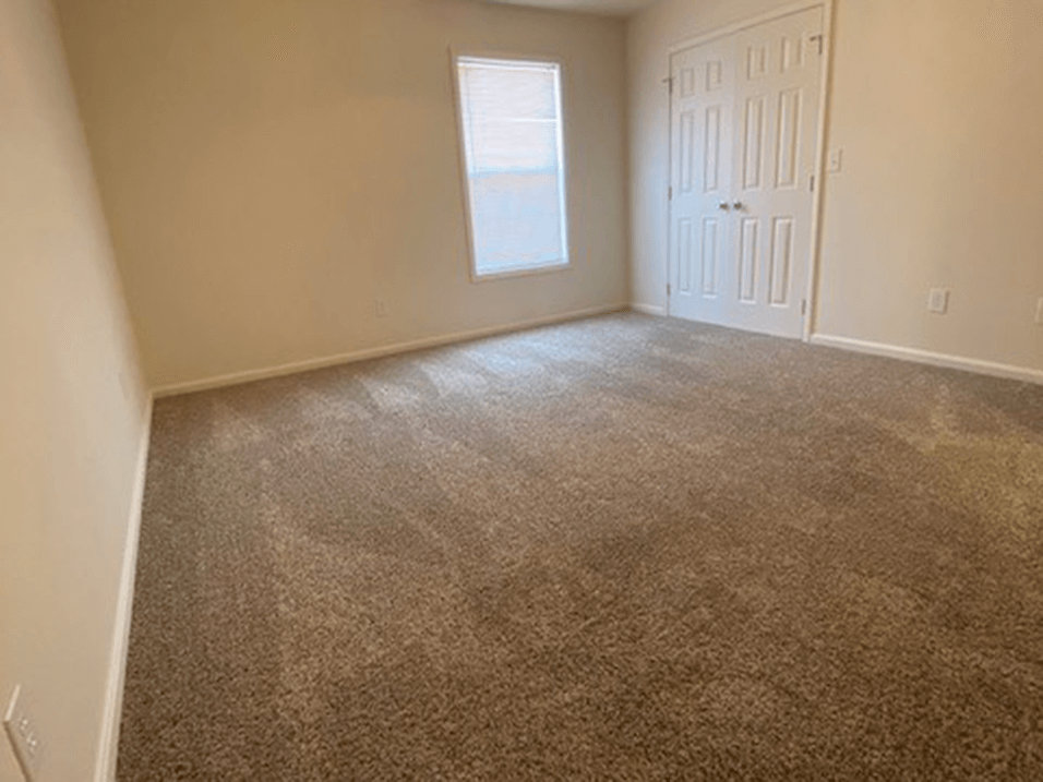 spacious bedroom with connected closet and window