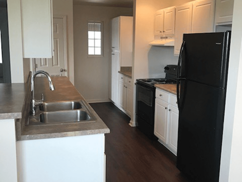 a kitchen with a sink and a black refrigerator