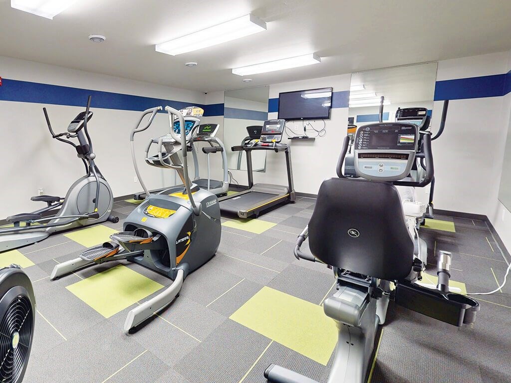 Cardio exercise equipment including treadmills and stationary bikes at The Chateau Apartments