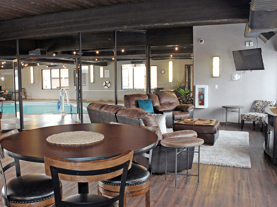 a large living room with a pool in the background