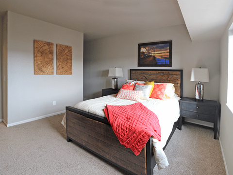 a bedroom with a bed and two paintings on the wall