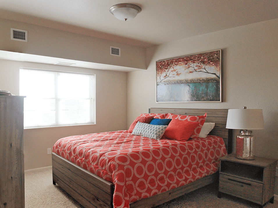 a bedroom with a bed and two windows