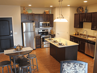 apartment kitchen with stainless steel appliances and a large island with a breakfast bar