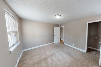 A room with a carpeted floor and a door in the middle.