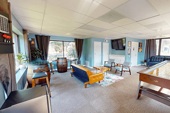 A living room with a blue couch and a wooden coffee table.