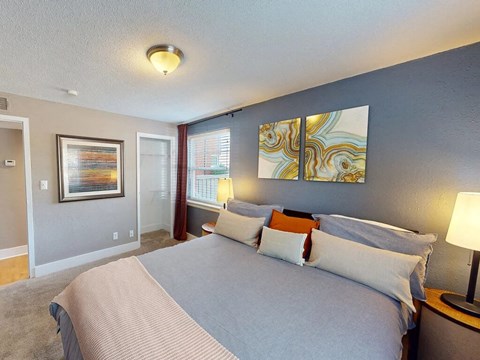 A bedroom with a large bed and a painting on the wall.