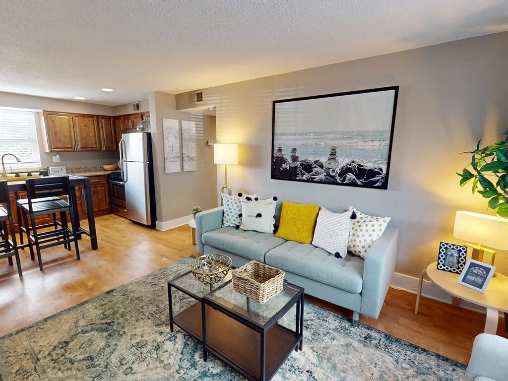 a living room and kitchen with a couch and a table