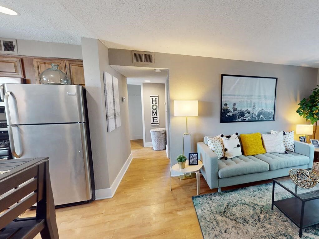 a living room with a refrigerator and a couch