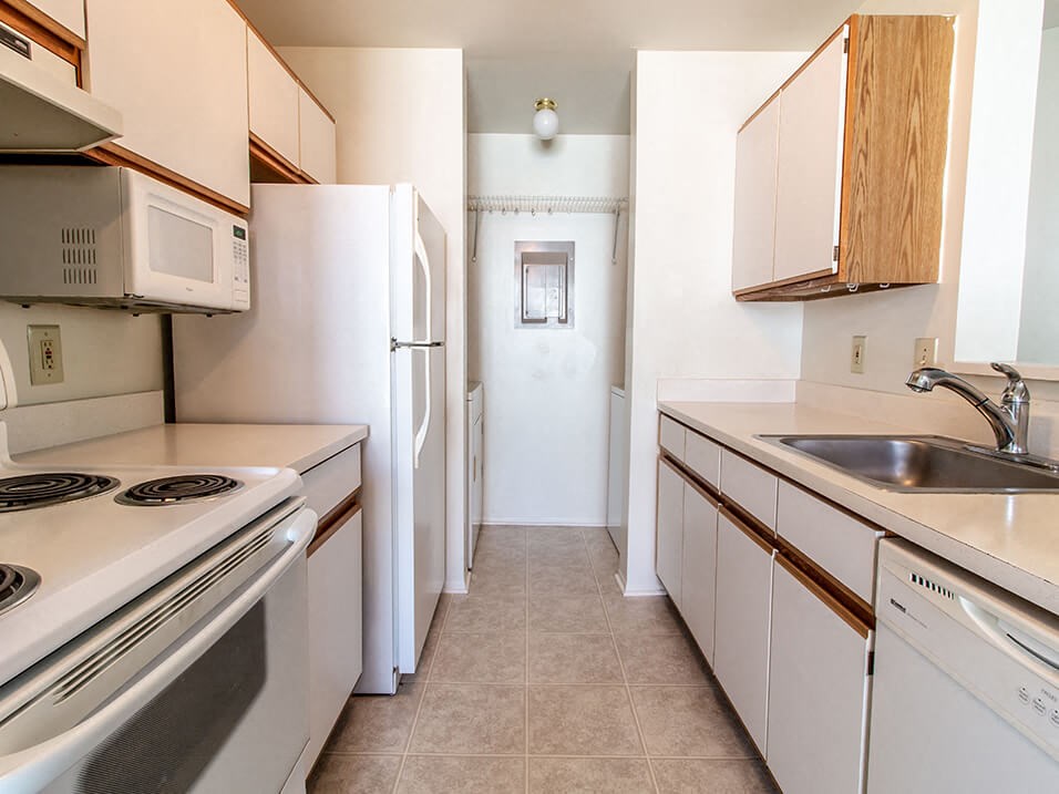 a kitchen with white appliances and wooden cabinets