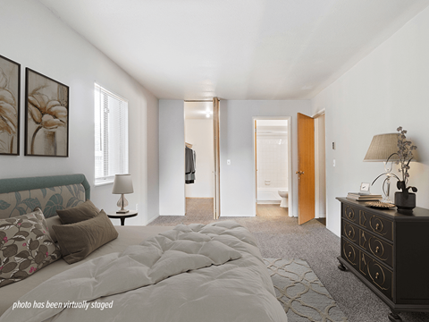 A bedroom with a large bed and a dresser.