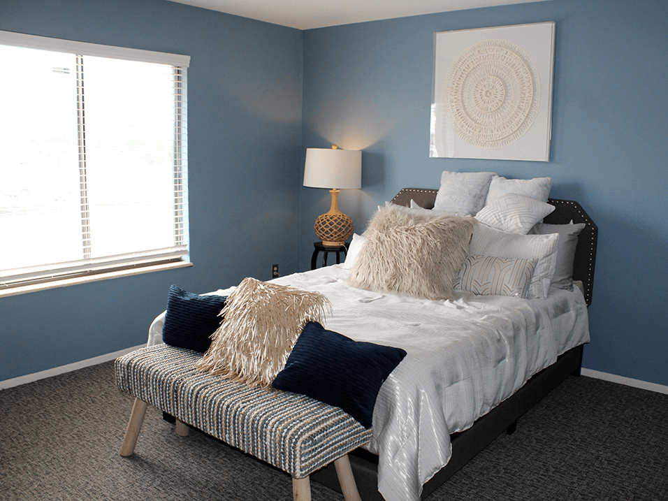 aparrtment bedroom with blue walls and a bed