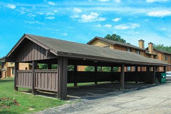 a covered parking lot with a building in the background