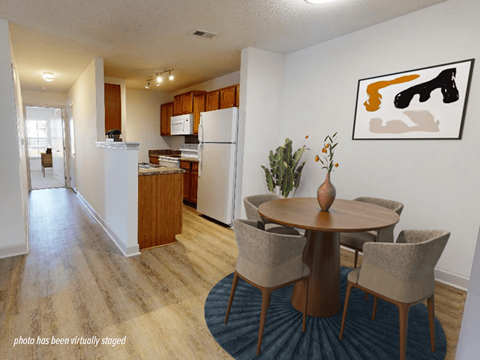 A kitchen with a dining table and chairs.