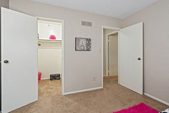 an empty bedroom with two doors and a closet