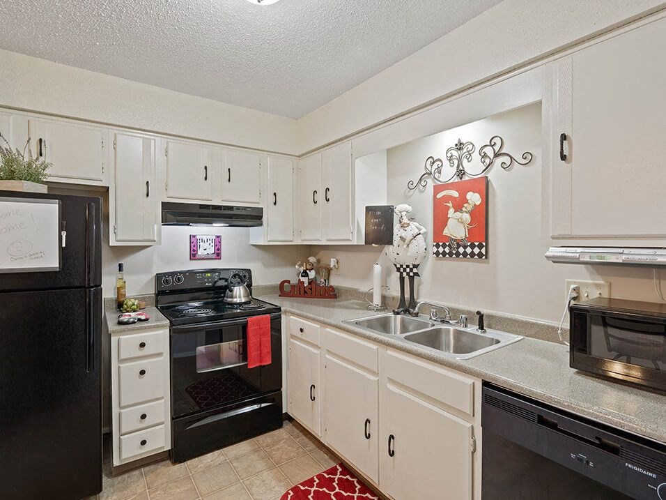 a kitchen with black appliances and white cabinets