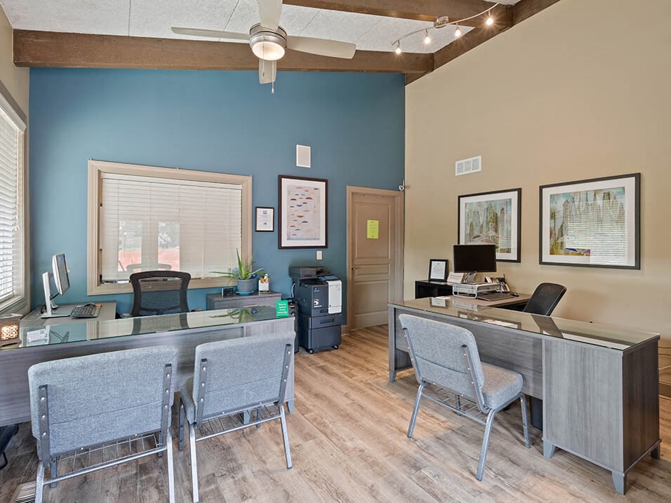 a office with two desks and chairs and a computer