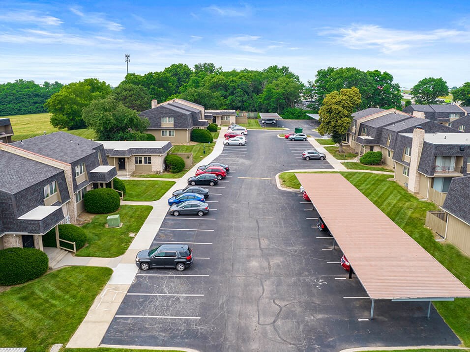 an aerial view of a neighborhood with cars parked in a parking lot