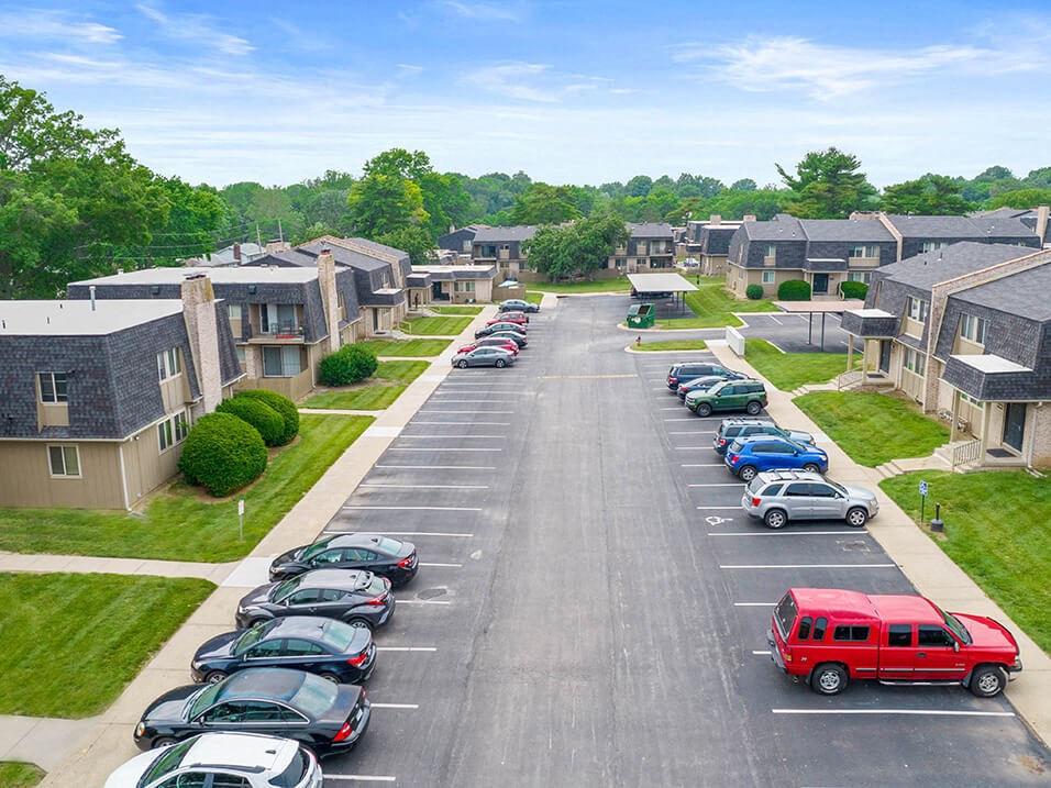 an aerial view of a parking lot with cars and houses