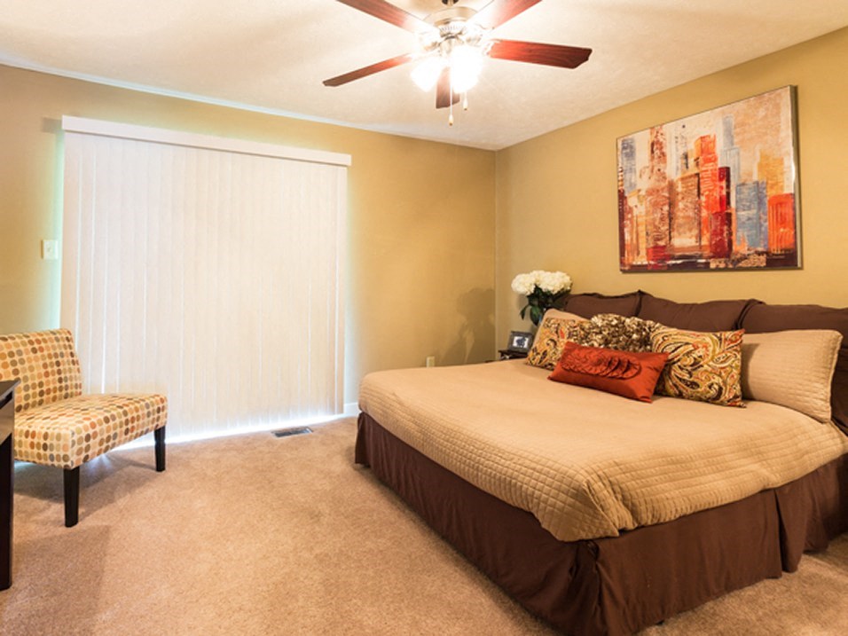 spacious bedroom with large window and overhead light
